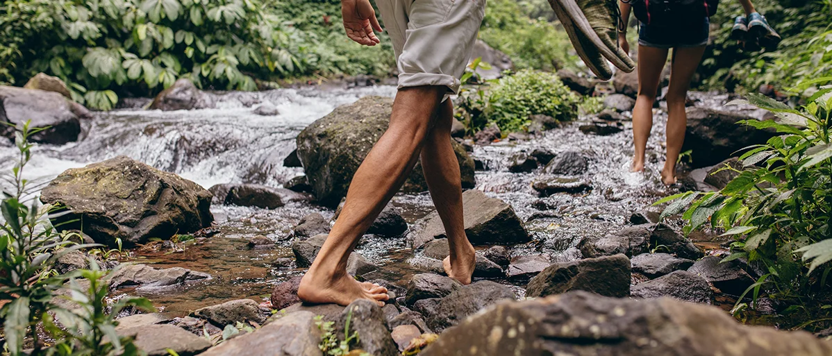 Person beim Wandern. Von der Ferse bis hoch zur Wade heben Markierungen den Wirkungsbereich von sensomotorischen Einlagen hervor.