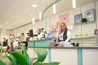 Abbildung einer Angestellten in einem Sanitätshaus, die telefoniert