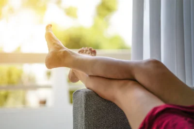 Zwei hochgelagerte Beine auf einer Couch