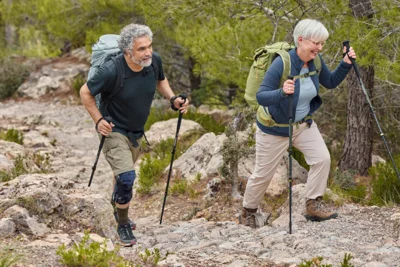 Zwei Personen beim Bergsteigen: Eine Person trägt eine Orthese.