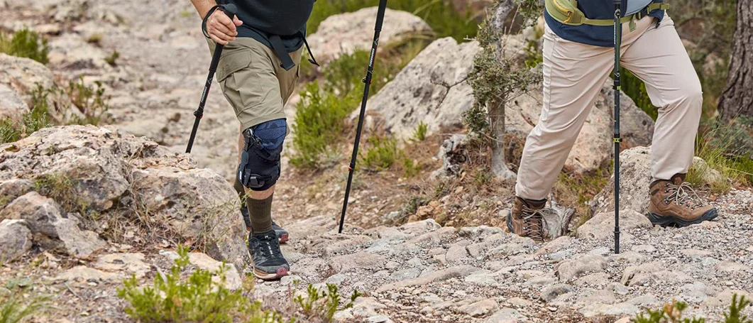 Zwei Personen beim Bergsteigen: Eine Person trägt eine Orthese.